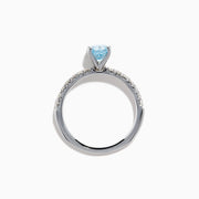 The Lab Grown Blue Diamond Solitaire Cushion Ring in 14K White Gold features a rectangular lab grown blue diamond at the center, accented with small clear round stones along the band.