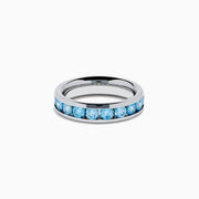 The Lab Grown Blue Diamond Channel Set Band in 14K White Gold features a row of round blue diamonds encircling the band, shown elegantly on a plain white background.