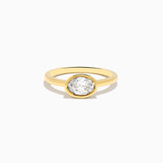 The Lab Grown Diamond East West Oval Ring in 14K Yellow Gold showcases a single lab diamond in a sleek bezel setting, presented against a plain white background.