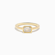 The Lab Grown Diamond East West Emerald-Cut Ring in 14K Yellow Gold features a lab diamond in a minimalist bezel setting, beautifully crafted and shown against a plain white background.