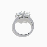 The Lab Grown Diamond Toi Et Moi Ring in 14K White Gold showcases emerald-cut and pear-shaped lab diamonds set side by side on a sleek band, displayed against a white background.