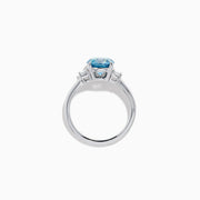 The Lab Grown Blue and White Diamond 3 Stone Ring in 14K White Gold features a striking round blue gemstone center with two rectangular lab grown diamonds on each side, all set in elegant white gold.