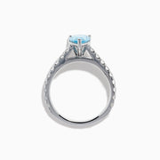 The Lab Grown Blue Diamond Solitaire Pear Ring in 14K White Gold features a striking pear-shaped blue diamond at the center, accented by a band adorned with small round white diamonds.
