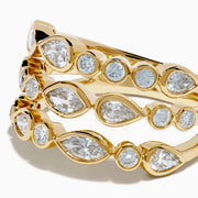 The Lab Grown Multi Shape Diamond Triple Row Bezel Ring in 14K Yellow Gold features three stacked bands with round and marquise lab grown diamonds set in bezel settings, creating a repeating diamond pattern around each row.