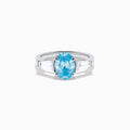 The Lab Grown Blue and White Diamond 3-Stone Ring in 14K White Gold showcases an oval blue diamond flanked by tapered white baguette diamonds, all set against a plain white background.