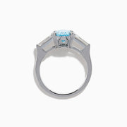 The Lab Grown Blue and White Diamond 3-Stone Ring in 14K White Gold showcases an oval blue diamond flanked by tapered white baguette diamonds, all set against a plain white background.