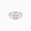 The Lab Grown Pink and White Diamond 3 Stone Ring in 14K White Gold features a striking round pink center stone with two rectangular white diamonds on each side, set against a white background.