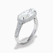The Lab Grown Diamond East-West Oval Halo Ring in 14K White Gold showcases a brilliant lab-grown diamond center, accented by sparkling stones along the band, beautifully set against a plain white background.