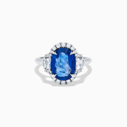 The Effy Hematian 18K White Gold Blue Sapphire and Diamond Halo Ring features a striking oval blue sapphire center, surrounded by round and rectangular diamonds, showcased on a plain white background.