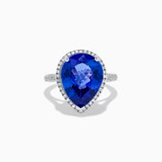 The 14K White Gold Pear Shape Tanzanite and Diamond Halo Ring features a pear-shaped blue tanzanite surrounded by a diamond halo on a delicate white gold band, displayed against a white background.