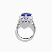 The 14K White Gold Pear Shape Tanzanite and Diamond Halo Ring features a pear-shaped blue tanzanite surrounded by a diamond halo on a delicate white gold band, displayed against a white background.