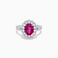 The 18K White Gold Pink Sapphire and Diamond Halo Ring features an oval pink sapphire surrounded by a diamond halo, with additional diamonds along the band for extra sparkle.