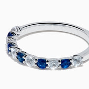 The Royale Bleu 14K White Gold Blue and White Sapphire Band Ring features alternating round blue and white sapphires on a sleek white gold band, shown against a white background.