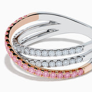 The 14K Two Tone Gold White and Pink Diamond Crossover Ring features three intersecting bands—two adorned with sparkling white and pink diamonds—shown on a white background.