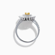 The Canare 18K Two Tone Gold Yellow and White Diamond Ring features an oval yellow centerpiece with a starburst halo of round and baguette white diamonds on a slim, diamond-studded band.