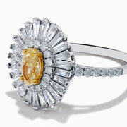 The Canare 18K Two Tone Gold Yellow and White Diamond Ring features an oval yellow centerpiece with a starburst halo of round and baguette white diamonds on a slim, diamond-studded band.