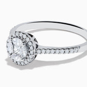 The Bouquet 14K White Gold Diamond Cluster Ring features an oval center diamond with a halo of smaller diamonds and a diamond-studded band, beautifully displayed against a plain white background.
