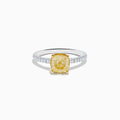 The Canare 18K Two Tone Gold Yellow and White Diamond Ring features a cushion-cut yellow diamond center held by gold prongs, accented with sparkling white diamonds along the band.