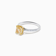 The Canare 18K Two Tone Gold Yellow and White Diamond Ring features a cushion-cut yellow diamond center held by gold prongs, accented with sparkling white diamonds along the band.