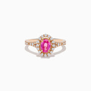 The 14K Rose Gold Pink Sapphire and Diamond Ring features an oval pink sapphire center, a halo of diamonds, and diamond accents on the band, all set against a white background.
