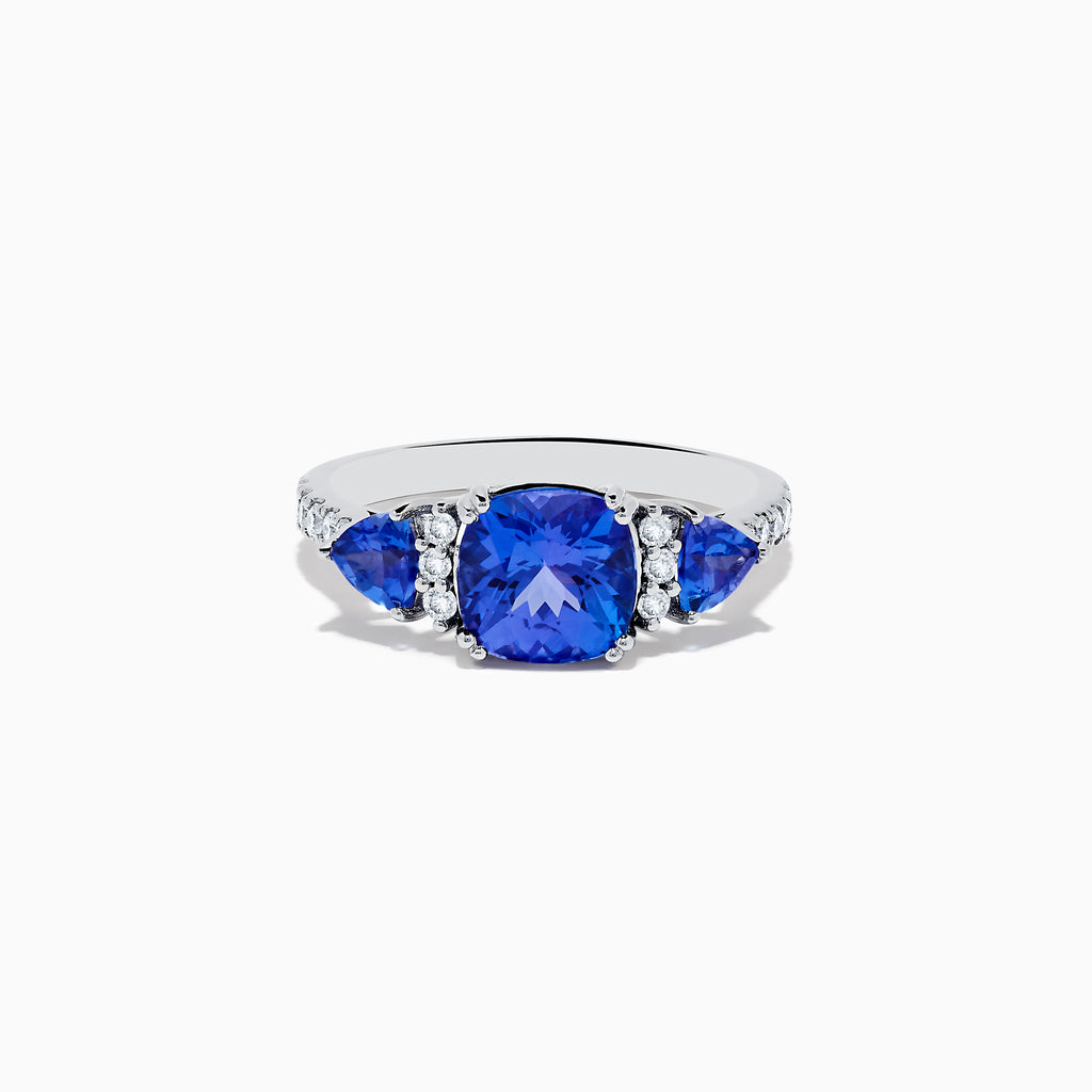 The Nahla Siri 14K White Gold Tanzanite and Diamond Ring showcases a large cushion-cut tanzanite center stone, flanked by two smaller tanzanites and accented with round diamonds along the band.