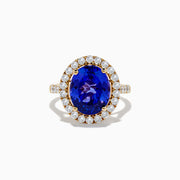 The Nahla Siri 14K Yellow Gold Tanzanite and Diamond Ring features a large oval blue tanzanite center stone encircled by a halo of small round white diamonds, displayed on a plain white background.