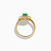 The Brasilica 14K Yellow Gold Emerald and Diamond Double Halo Ring showcases a rectangular green emerald at the center, accented by two rows of sparkling round white diamonds in an elegant scalloped halo design.