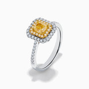 The Canare 18K Two Tone Gold White and Yellow Diamond Ring features a large rectangular yellow gemstone, double halo of white diamonds, and diamond accents on the elegant band.