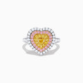 The Trio 18K Tri Color Gold White, Pink, and Yellow Diamond Heart Ring features a yellow diamond center, surrounded by pink and white diamonds on an 18K gold band for a luxurious finish.