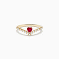 The 14K Yellow Gold Ruby Heart and Diamond Contoured Ring features a V-shaped band set with white diamonds and a vivid ruby heart at its center.