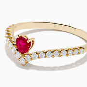The 14K Yellow Gold Ruby Heart and Diamond Contoured Ring features a V-shaped band set with white diamonds and a vivid ruby heart at its center.