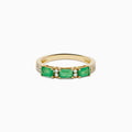 The 14K Yellow Gold Emerald and Diamond Band showcases three rectangular green emeralds set horizontally, each separated by small round diamonds, with extra diamond accents on the sides.
