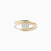 The 14K Yellow Gold Channel Set Diamond Bouquet Ring features a central round-cut diamond and channel set diamonds in a halo on an open band, shown on a white background.