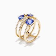 The 14K Yellow Gold Tanzanite and Diamond Multi-Row Statement Ring features three stacked bands set with white diamonds and pear, oval, and cushion-cut blue tanzanite gemstones.