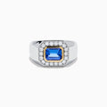 The Men's 14K Two Tone Gold East West Emerald Cut Tanzanite and Diamond Ring features a rectangular blue tanzanite set in a gold bezel, framed by white diamonds, all beautifully crafted against a plain white background.