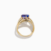 The 14K Yellow Gold Tanzanite and Diamond Crossover Ring showcases an oval tanzanite center stone accented by intersecting diamond-encrusted bands for a brilliant, modern look.