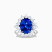 The Hematian 14K White Gold Tanzanite and Diamond Ring showcases a striking oval blue tanzanite center with a halo of round white diamonds, displayed on a plain white background.