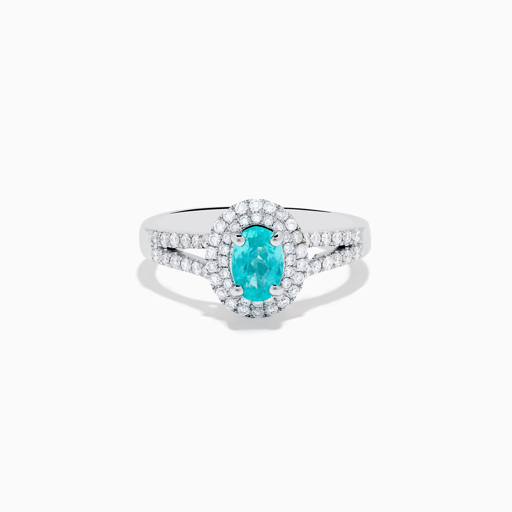 The 18K White Gold Paraiba and Diamond Ring showcases an oval Paraiba gemstone at the center, encircled by a halo of sparkling diamonds and accented with additional diamonds along its elegant split shank band.