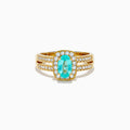 The 18K Yellow Gold Paraiba and Diamond Halo Ring showcases a central oval Paraiba turquoise, surrounded by a diamond halo and additional diamonds on the split shank band, all set in yellow gold and shown against a white background.