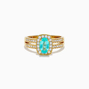 The 18K Yellow Gold Paraiba and Diamond Halo Ring showcases a central oval Paraiba turquoise, surrounded by a diamond halo and additional diamonds on the split shank band, all set in yellow gold and shown against a white background.