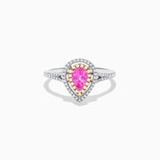 The 14K Two Tone Gold Pink Sapphire and Diamond Halo Ring showcases a pear-shaped pink sapphire center, double diamond halo with gold accents, and extra diamonds set along its two tone gold band.