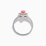 The 14K Two Tone Gold Pink Sapphire and Diamond Halo Ring showcases a pear-shaped pink sapphire center, double diamond halo with gold accents, and extra diamonds set along its two tone gold band.