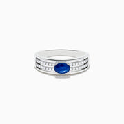 The 925 Sterling Silver Blue Sapphire and Diamond Ring showcases an oval blue sapphire centerpiece accented by two rows of sparkling round white diamonds along the band.