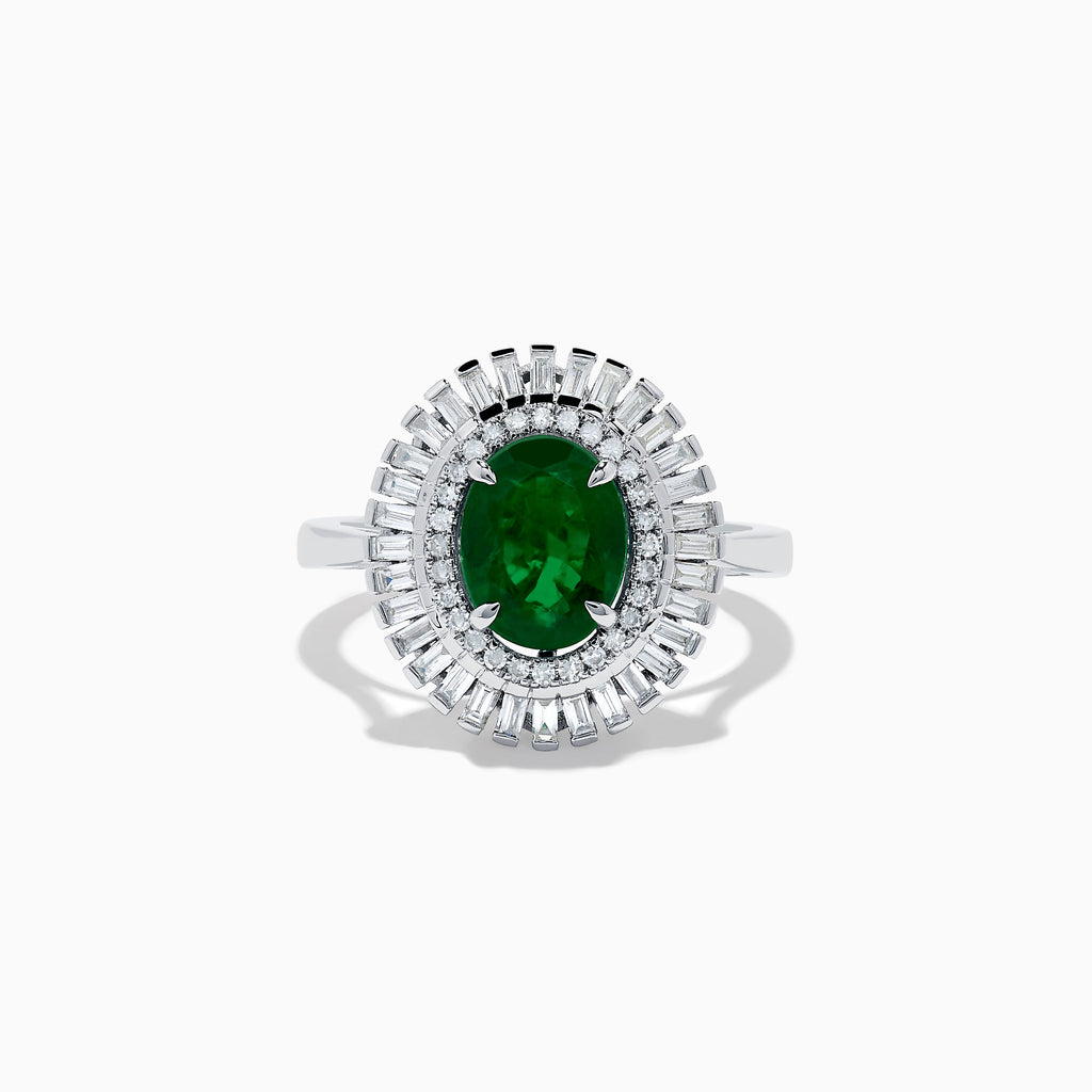 The 14K White Gold Emerald and Diamond Ring features an oval emerald center accented by two rows of baguette and round diamonds in a radiant halo design.