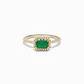 The 14K Yellow Gold Emerald and Diamond Ring features a square-cut emerald center, a halo of white diamonds, and a twisted band design.