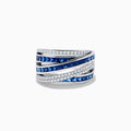 The Royale Bleu 14K White Gold Sapphire and Diamond Crossover Ring showcases alternating rows of square blue sapphires and white diamonds in a bold, layered design. Set on a plain white background.