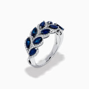 The 14K White Gold Sapphire and Diamond Leaf Motif Ring features alternating marquise-shaped blue sapphires and small round diamonds arranged in a woven, leaf-like design.