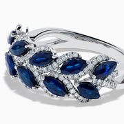 The 14K White Gold Sapphire and Diamond Leaf Motif Ring features alternating marquise-shaped blue sapphires and small round diamonds arranged in a woven, leaf-like design.