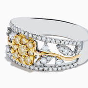 This 14K two tone gold flower ring features a wide band with a central cluster of yellow diamonds, surrounded by small white diamonds, and elegant gold and silver accents.