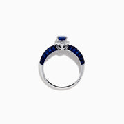The 14K White Gold Blue Sapphire and Diamond Ring showcases a striking oval blue sapphire center, surrounded by sparkling diamonds, with additional sapphires set along the band.
